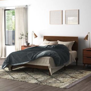 Wooden bed frame in white bedroom
