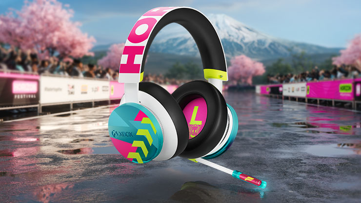 Colorful gaming headset with Xbox branding on reflective surface. Background features cherry blossoms, cheering crowd, and a snow-capped mountain. Vibrant, energetic vibe.