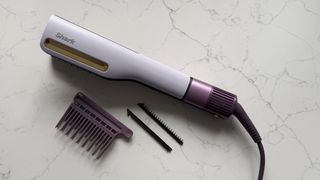 Top-down view of the Shark SilkiPro Straight with all three comb attachments laid out alongside it on a marble surface
