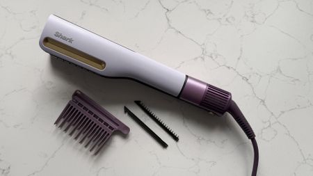 Top-down view of the Shark SilkiPro Straight with all three comb attachments laid out alongside it on a marble surface