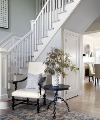 Pale gray entrway with accent chair and table