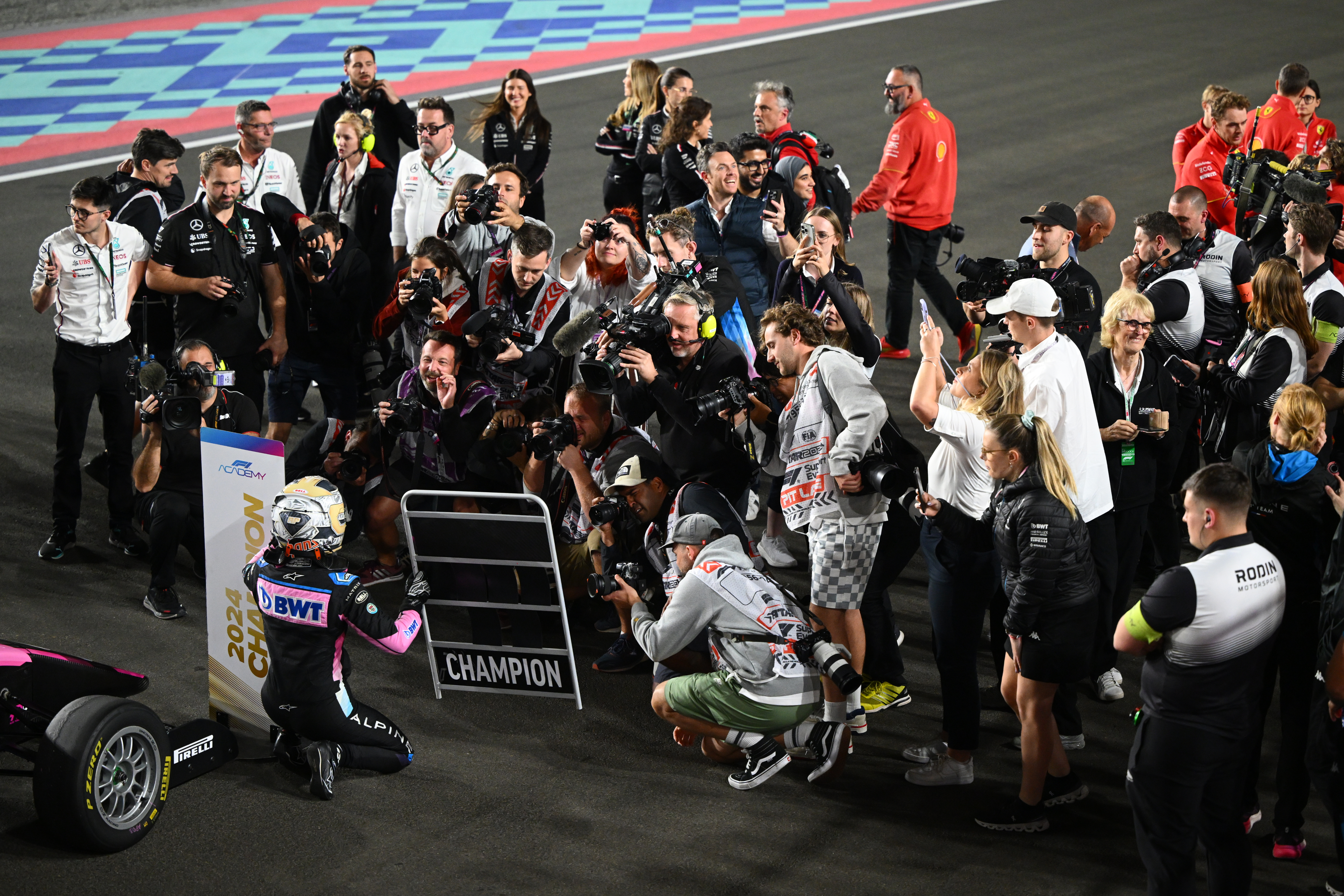 Abbi Pulling celebrating becoming the 2024 F1 Academy Champion infront of a crowd of press