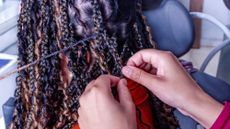 Black woman getting hair braided