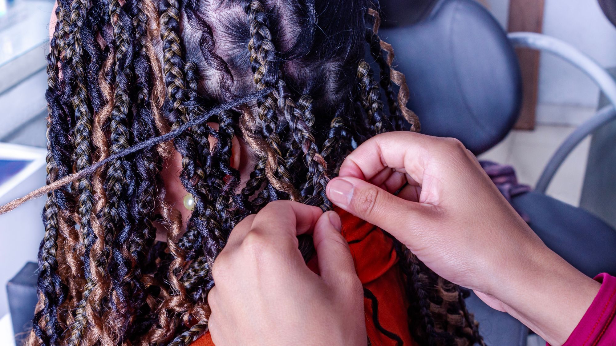 Black woman getting hair braided