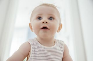 A curious baby boy model looking up in bright light