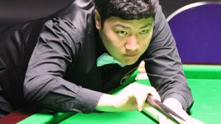 Yan Bingtao gets down on a shot on his way to winning The Masters