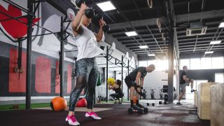 Woman performs devil’s press exercise with dumbbells