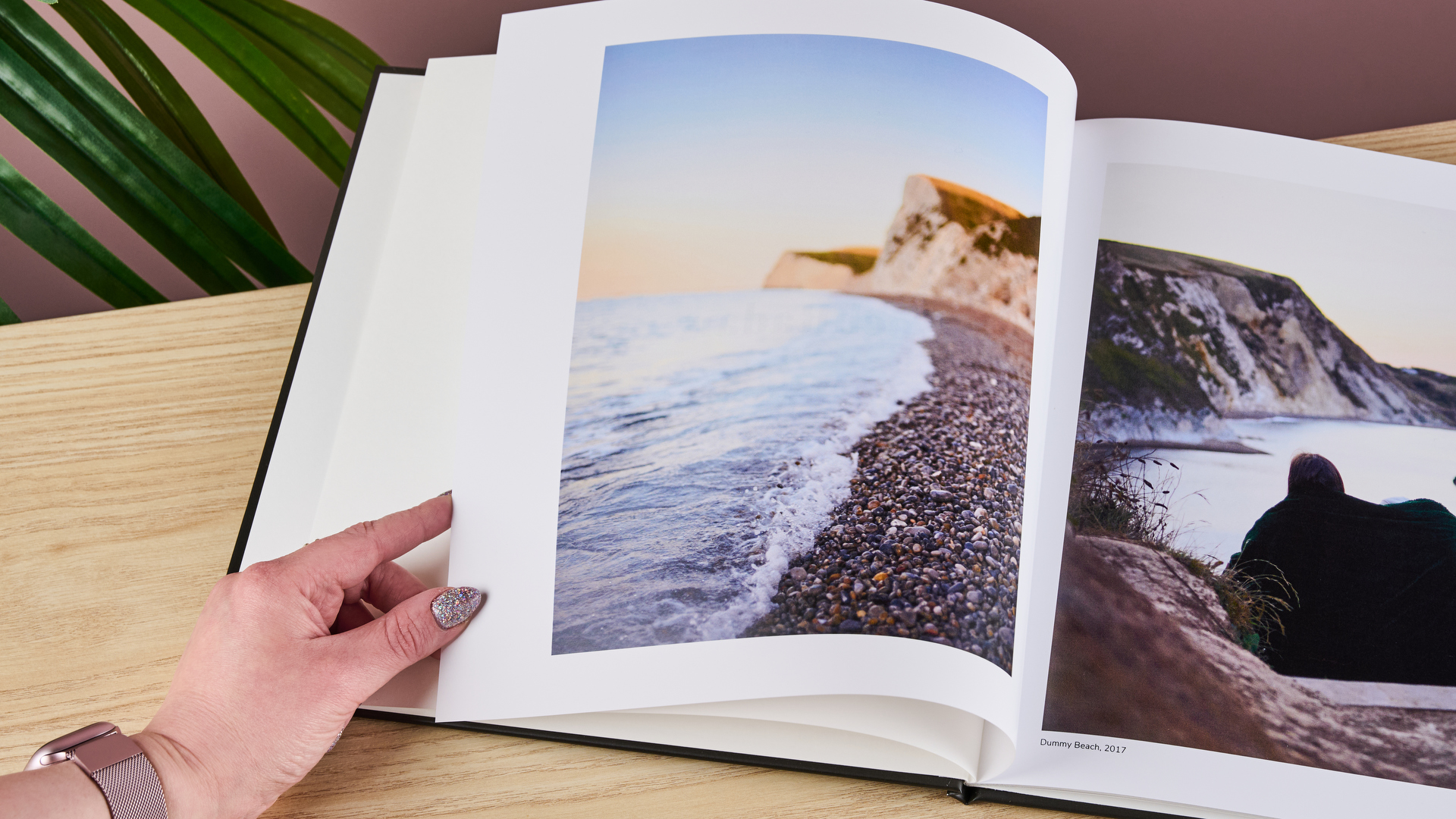 A woman is turning a page of the Once Upon photo book.