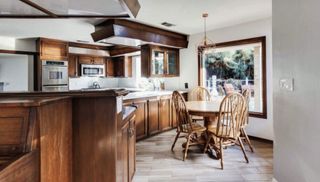 A dated kitchen with wooden cabinetry
