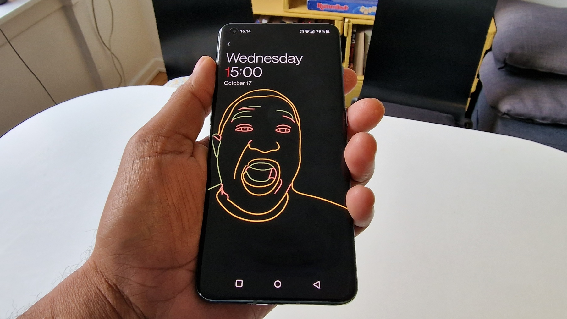 En hand håller upp en OnePlus 10 Pro med skärmen aktiv och vänd mot kameran.