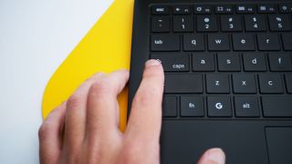 A hand hitting the Quick Insert key on a Samsung Galaxy Chromebook Plus