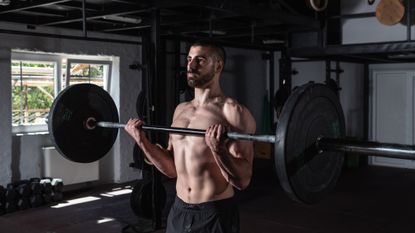 Man lifting a heavy barbell to build muscle