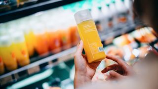 Woman looking at fruit juice in supermarket