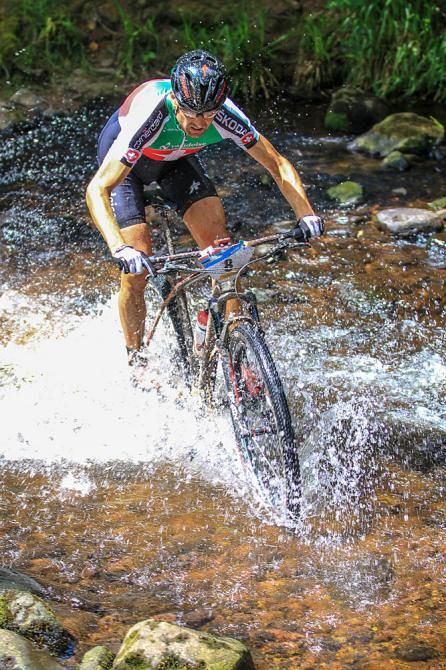 Christoph Sauser splashes through a water crossing