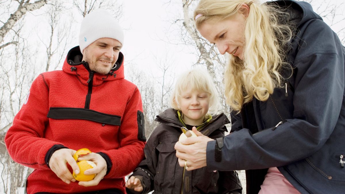 Family eating oranges on hike