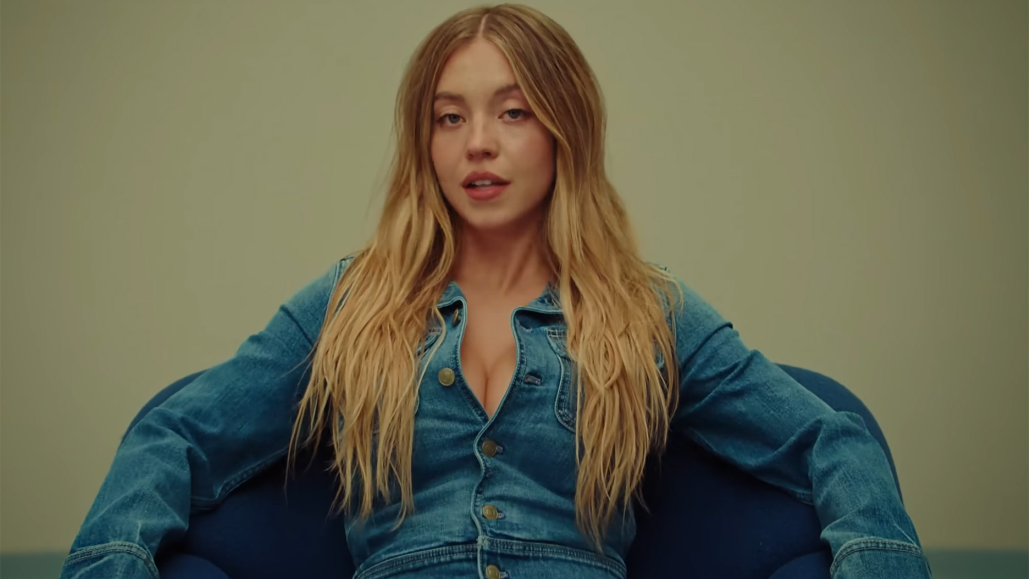 Sydney Sweeney in a denim long-sleeved top and denim wide-legged jeans in an ad for American Eagle.