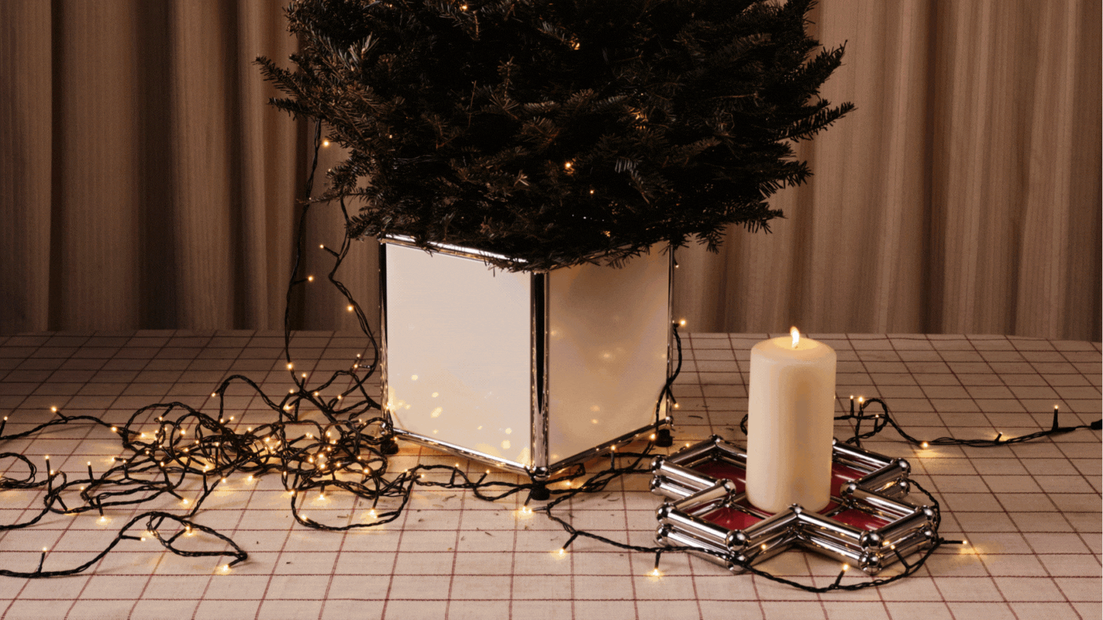 A rotating gif showcasing showroom-styled, wheeled christmas tree planters in chrome and beige or rose pink, mixed with table trays filled with chocolate coins and colorful crayons.