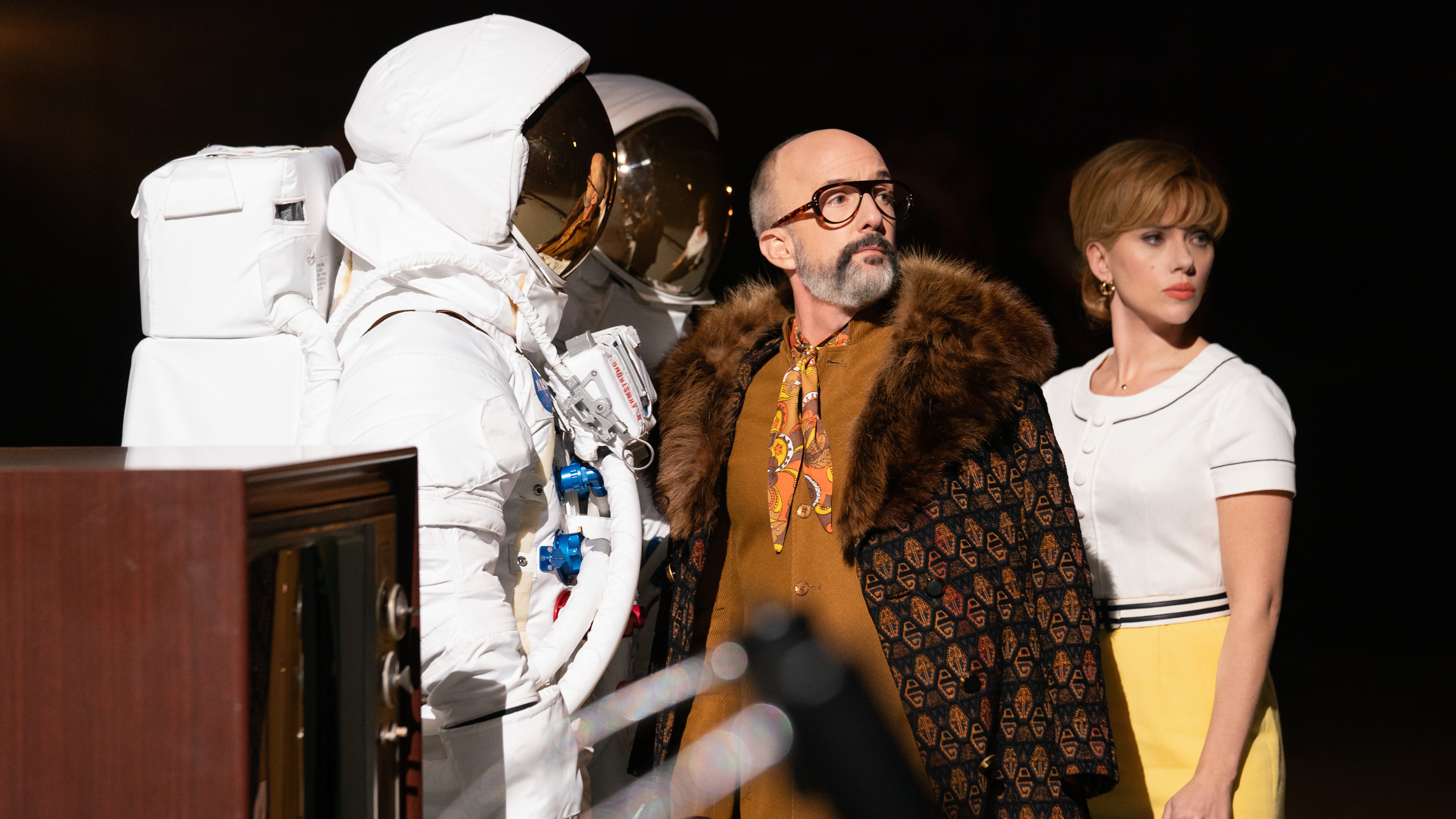 Lance (Jim Rash) und Kelly (Scarlett Johansson) (LR) stehen im Film neben Requisiten im Astronauten-Stil 