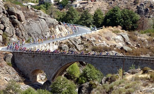 The peloton crosses a bridge near Avila