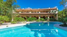 A look a the sprawling Manola house villa in Diani Beach Kenya during the day with a large pool and verdant landscape