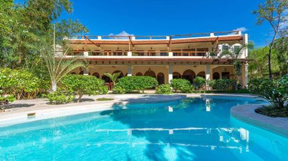A look a the sprawling Manola house villa in Diani Beach Kenya during the day with a large pool and verdant landscape