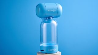A blue Sodapop Bluetooth speaker that screws onto any regular-sized bottle