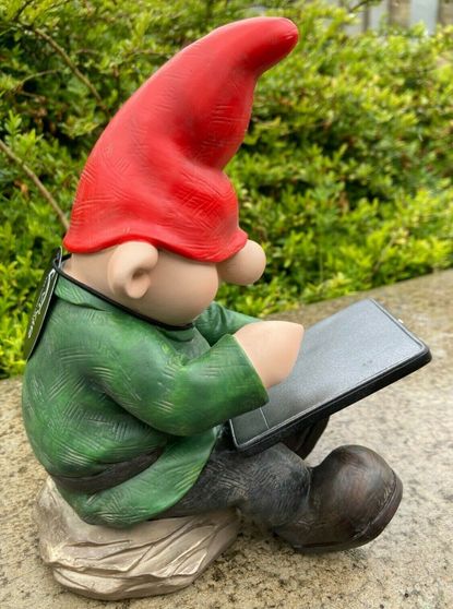 A gnome playing Candy Crush on his iPad