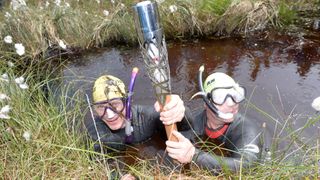 Bog snorkelers with the Commonwealth Games Baton at Peatlands Park during the Glasgow 2014 Baton Relay