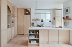 a plywood kitchen with minimalist styling and circular cut outs