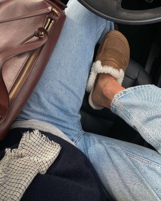 Self-taken photo by @smythsisters in a car showing faded jeans, a burgundy bag, sweater, scarf, anklet, and cozy slippers.