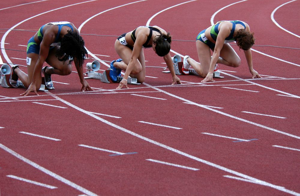 Women athletes line up for the start of a track race