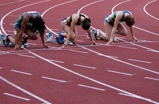 Women athletes line up for the start of a track race