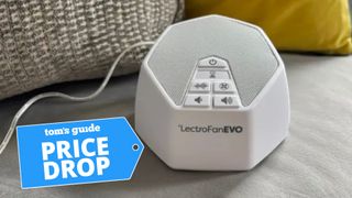 The LectroFan EVO White Noise Machine perched on a grey couch. In the lower left-hand foreground, there's a PRICE DROP deal badge.