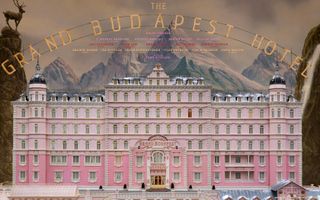 Front of the pink Grand Budapest Hotel with mountain backdrop and title from the film