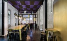 Wide shot of interior of restaurant including purple ceilings