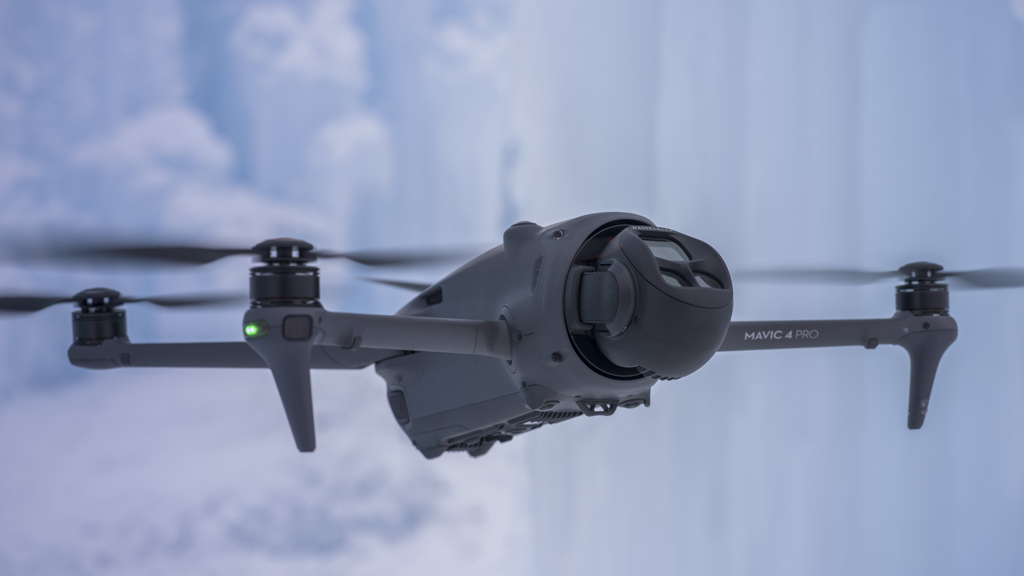 DJI Mavic 4 Pro drone in flight, camera angled up, icy backdrop