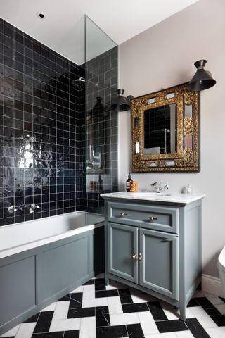 Bathroom with shiny black wall tiles and black and white chevron floor tiles