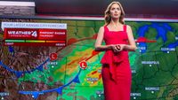 A blonde woman in a red dress presenting a weather forecast.