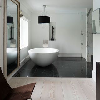 bathroom with white wall white bowl on black tile flooring
