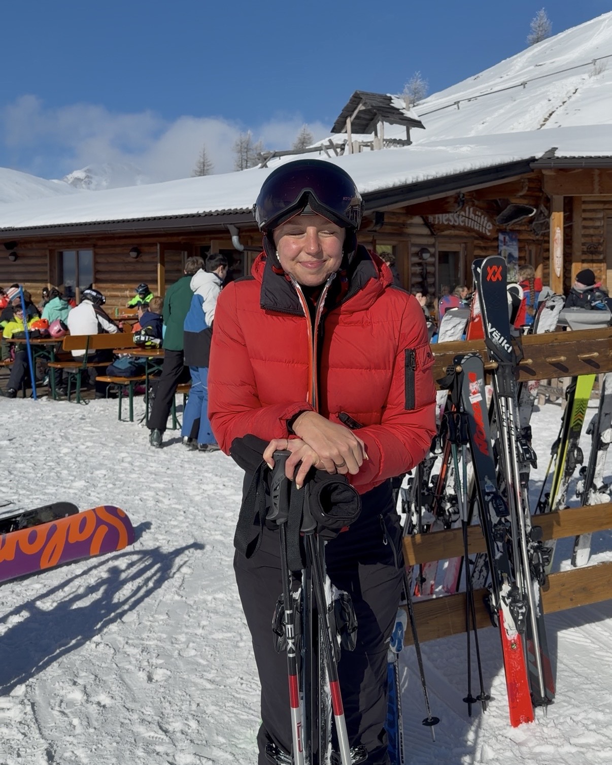 A woman in a red ski jacket on a mountain