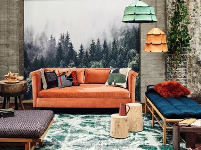 A living room with an orange sofa, and orange &amp; green lamp