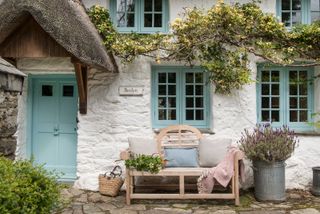 small front garden ideas: country cottage with bench and climbing plant