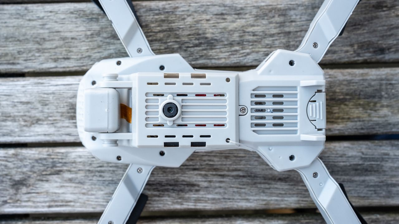 Cheap 4K drone on a table underside and battery
