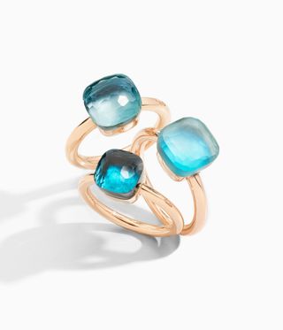 Three gold rings with clear blue topaz on