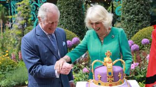 King Charles and Queen Camilla cutting a cake
