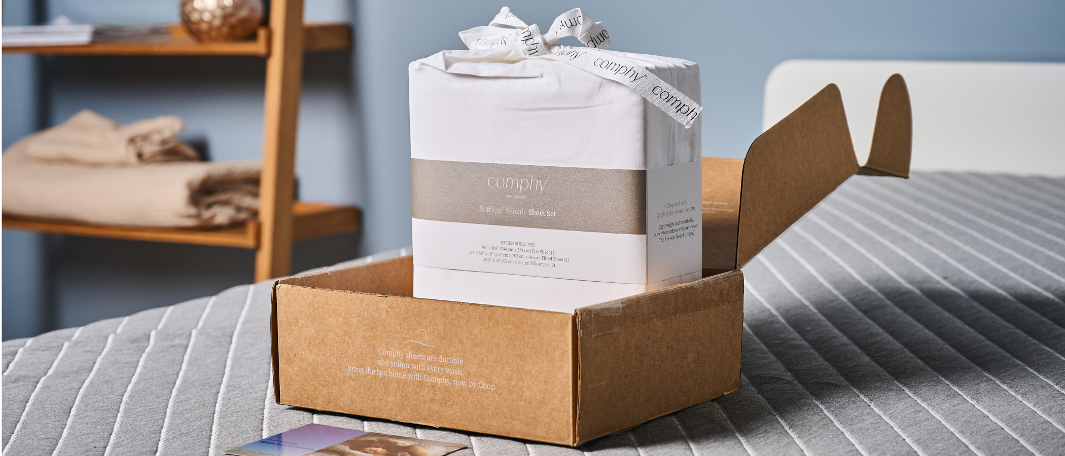 Coop Percale sheet set in the package placed on the bed in TG slep studio