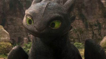 A shot of toothless looking curious by a rock wall in How To Train Your Dragon.