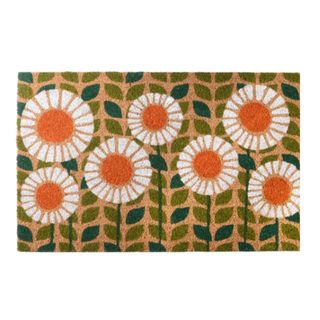 A brown welcome mat with white flowers and green stems