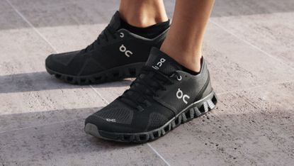 On Cloud X shoe review: a model wears a black pair of the workout shoes
