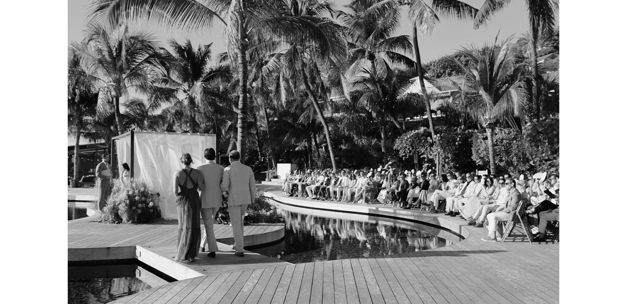 The groom and his parents walking down the aisle.